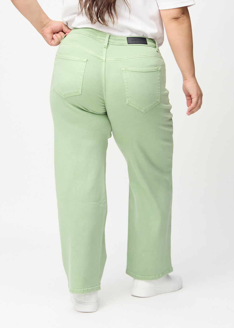 Lysegrønne loose jeans set bagfra på en plus-size model, så man kan se hele produktet.