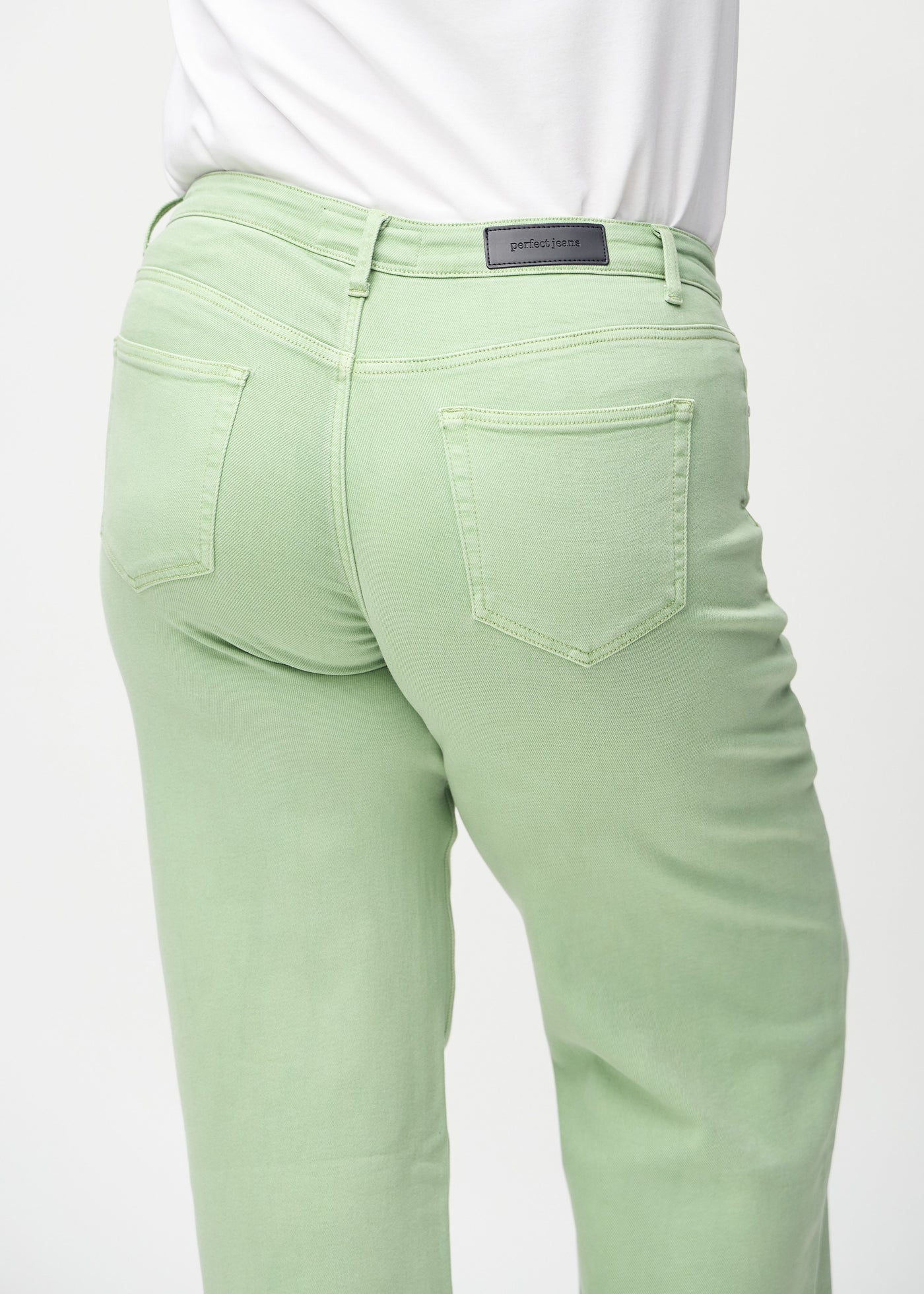 Lysegrønne loose jeans set bagfra tæt på en plus-size model for at vise detaljer.