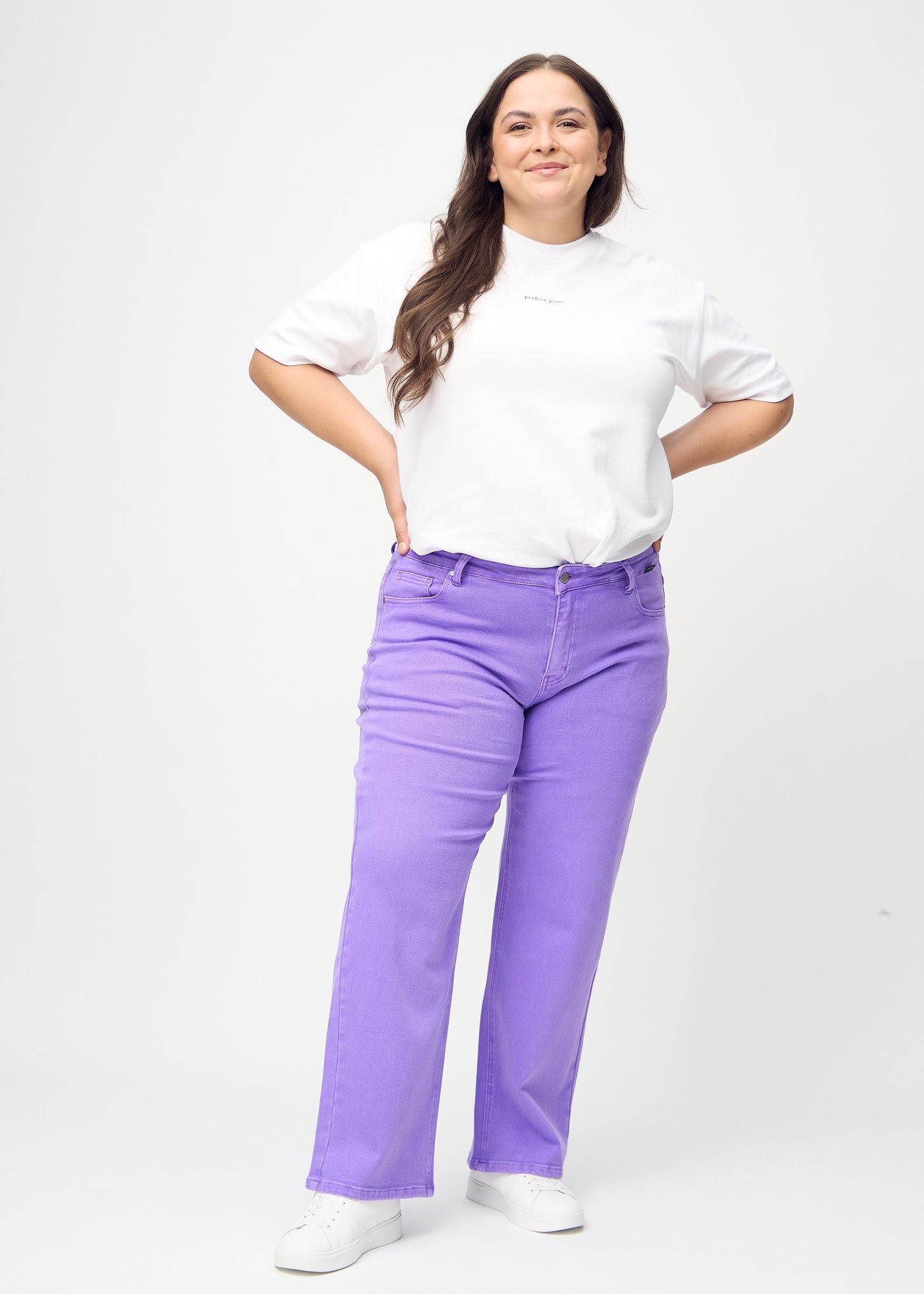 Fuldt billede af en plus-size model i lilla loose jeans.