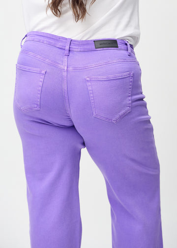 Lilla loose jeans set bagfra tæt på en plus-size model for at vise detaljer.