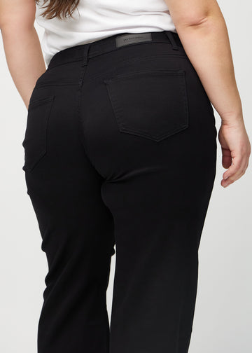 Sorte loose jeans set bagfra tæt på en plus-size model for at vise detaljer.