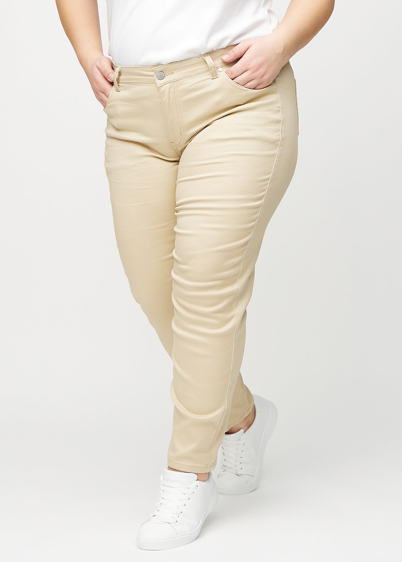 Beige slim jeans, modelnavn Gazelles, som sidder tæt til benet, dog lidt løsere ved anklen, dog lidt løsere ved anklen, på en plus-size model, set forfra.