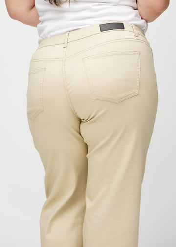 Beige loose jeans set bagfra tæt på en plus-size model for at vise detaljer.