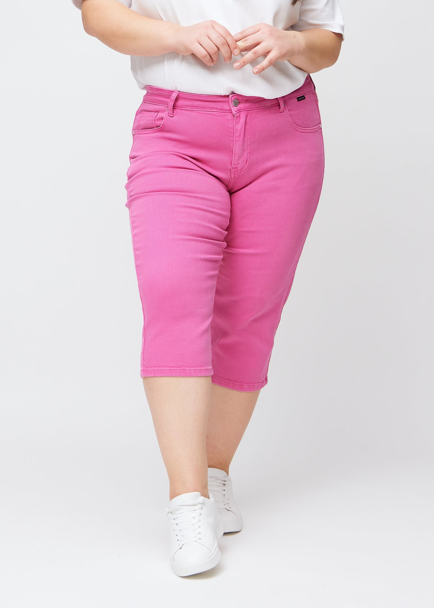 Lyserøde slim capris, farve Flamingos, med tætsiddende pasform og længde lige under knæet – set forfra på plus-size model.