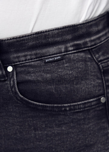 Forlommen på et par mørkegrå denim loose jeans, hvor man kan se logoet på en plus-size model.