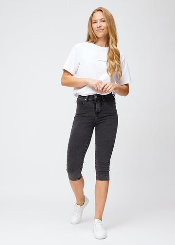 Fuldt billede af model i mørkegrå denim skinny capris.