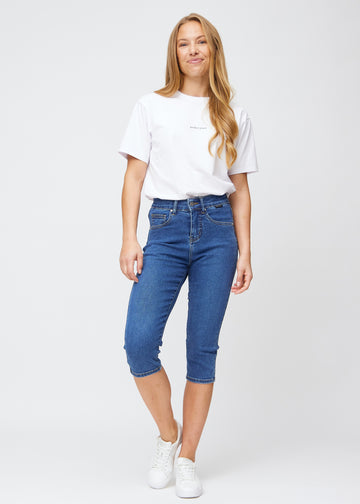 Fuldt billede af model iført mørkeblå denim slim capris.