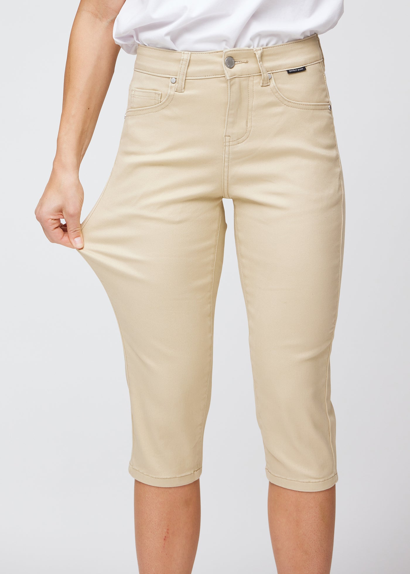 Model strækker caprisene ved låret for at vise det bløde og fleksible stretch.