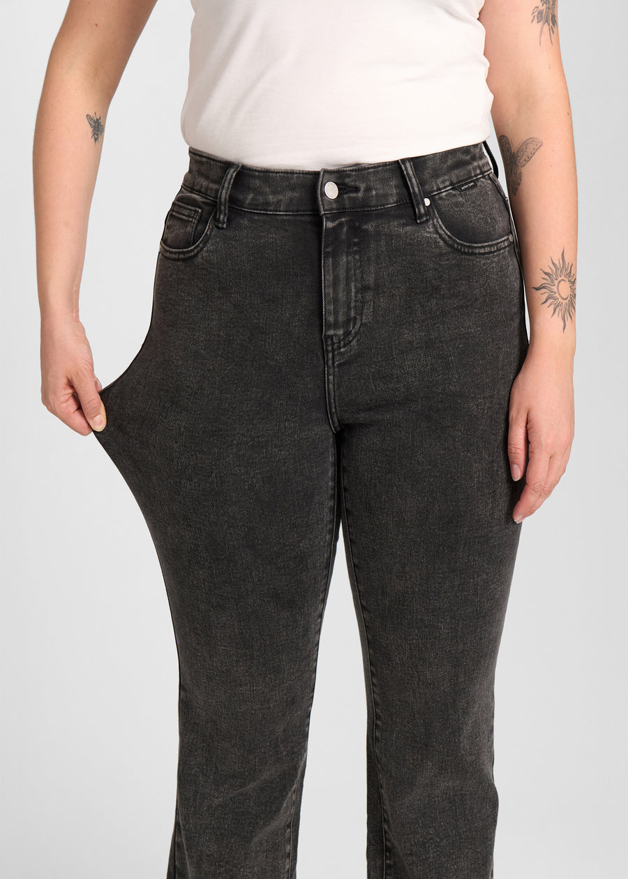 Model strækker jeansene ved låret for at vise stretch.