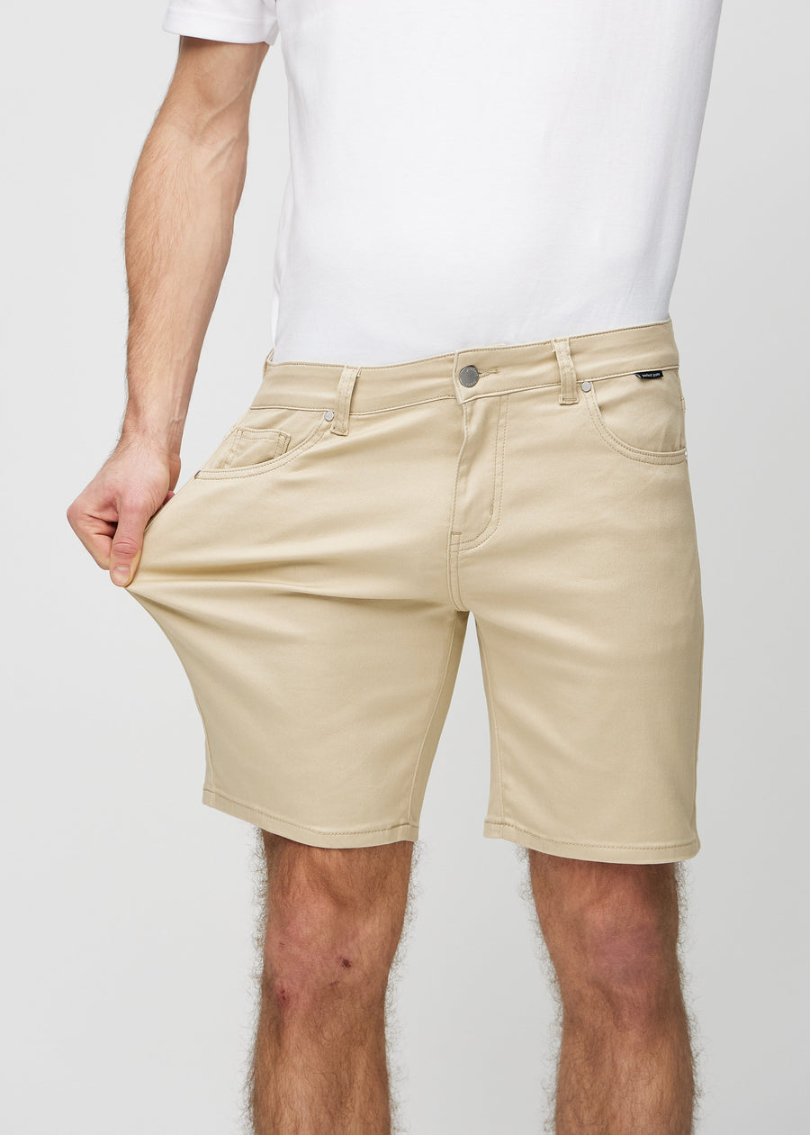 Model strækker shortsene ved låret for at vise stretch.