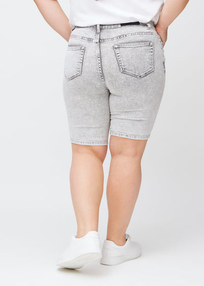 Lysegrå denim skinny middle shorts set bagfra på en plus-size model, så man kan se hele produktet.