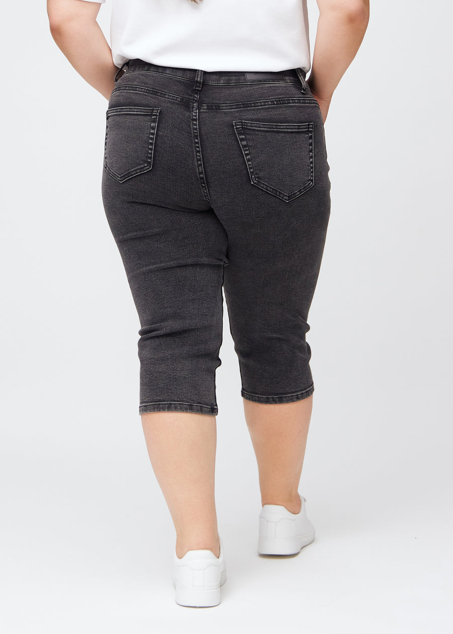 Mørkegrå denim slim capris set bagfra på en plus-size model – tydeligt billede af hele produktet og lommer.