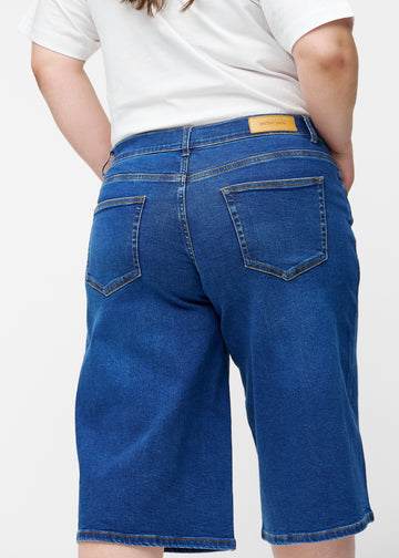 Løse, mørkeblå denim capris i farven Oceans set bagfra tæt på på plus-size model for at vise pasform og detaljer.