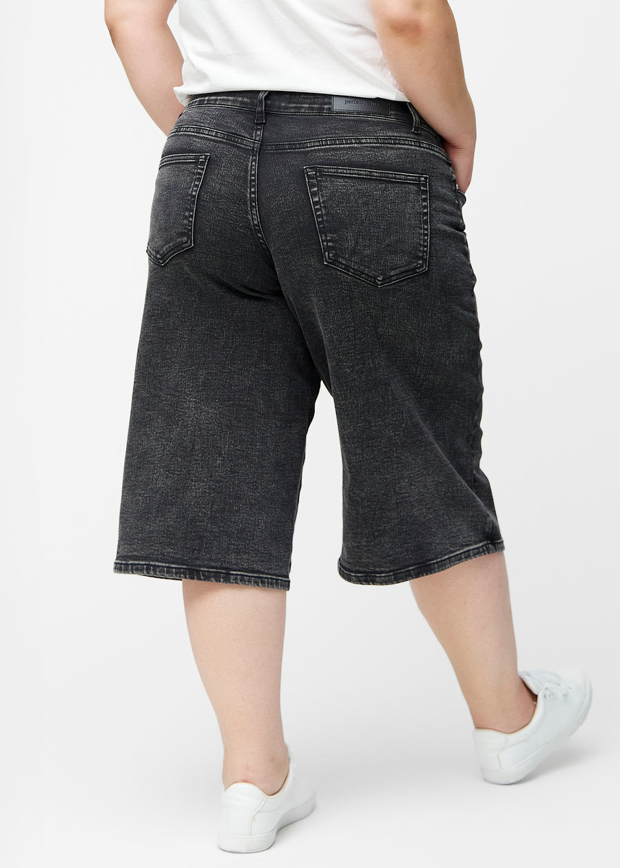 Løse, mørkegrå denim capris i farven Shadows set bagfra på plus-size model, så pasform og længde kan ses.
