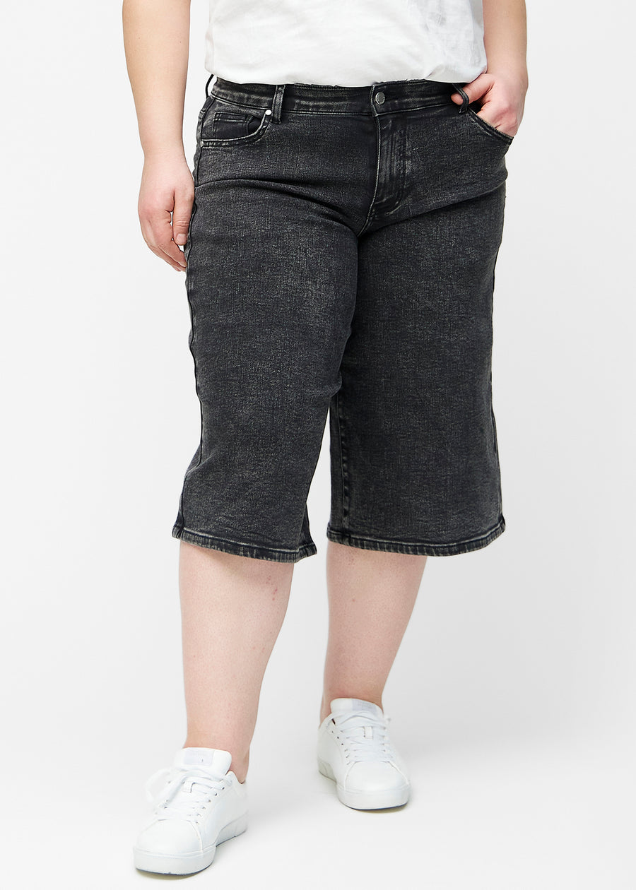 Løse, mørkegrå denim capris i farven Shadows set forfra på plus-size model, der sidder til ved hoften og falder løst ned.