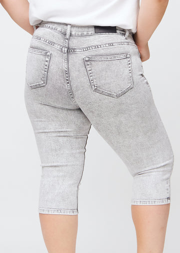Lysegrå denim skinny capris set bagfra tæt på en plus-size model for at vise detaljer.