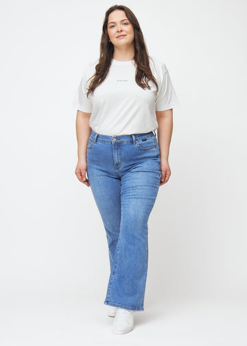 Fuldt billede af en plus-size model i blå mid-rise bootcut jeans i denimfarven Rivers.