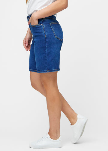 Løse, mørkeblå denim shorts i farven Oceans set fra siden på model, hvor den brede pasform og længden til lige over knæet er synlig.