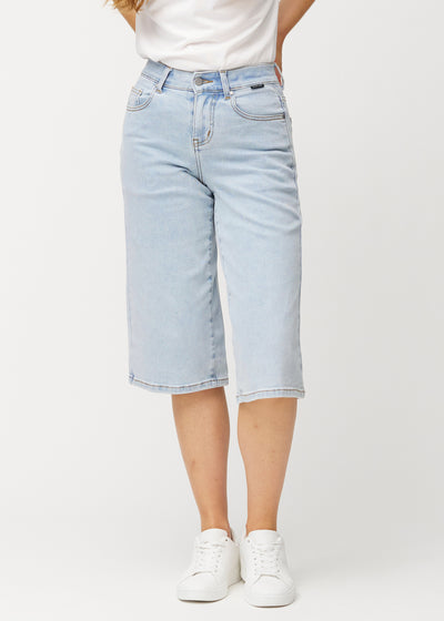 Loose, light blue Waves denim capris that sit close at the hips and fall loosely over the thighs to just below the knee, seen from the front.