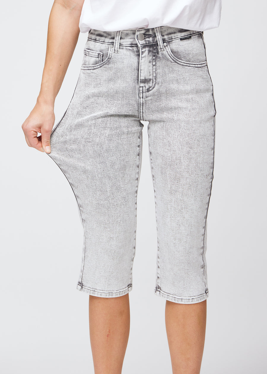 The model stretches the capris at the thigh to show the stretch.