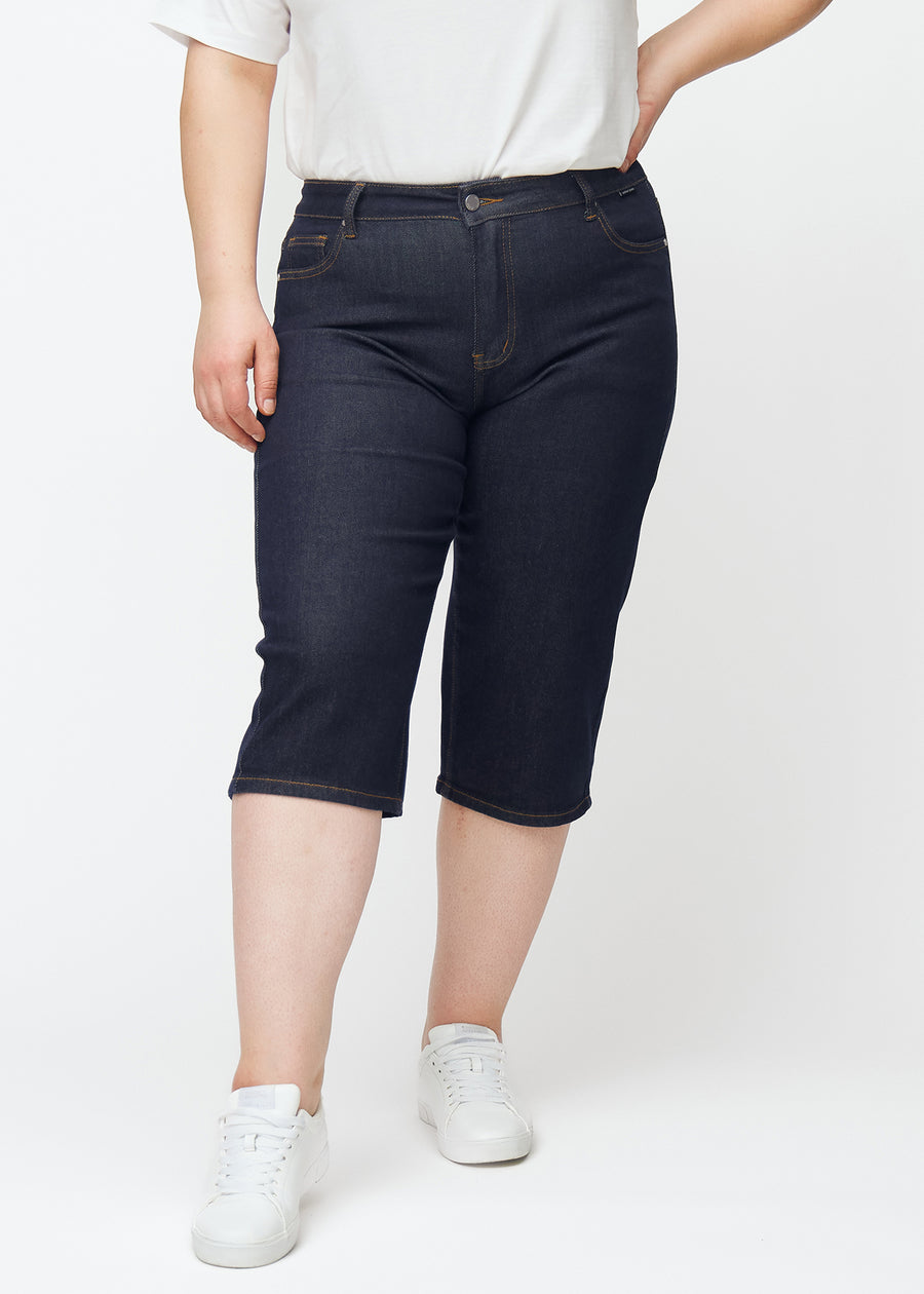 Deep dark blue denim capris for women in the colour Midnights with a regular fit seen from the front on a plus-size model.