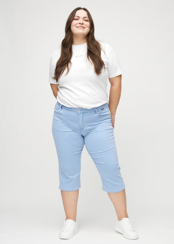 Full image of a plus-size model in light blue regular capris.