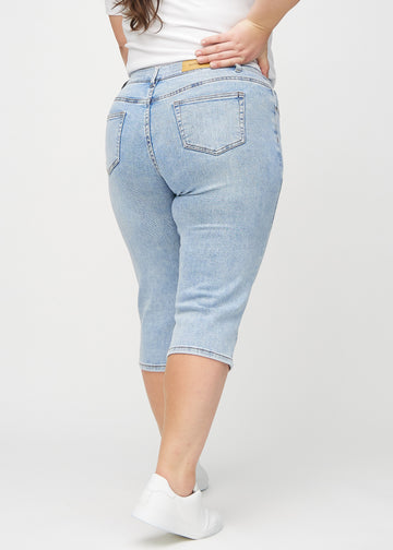 Light denim regular capris seen from the back on a plus-size model, so the entire product can be seen.