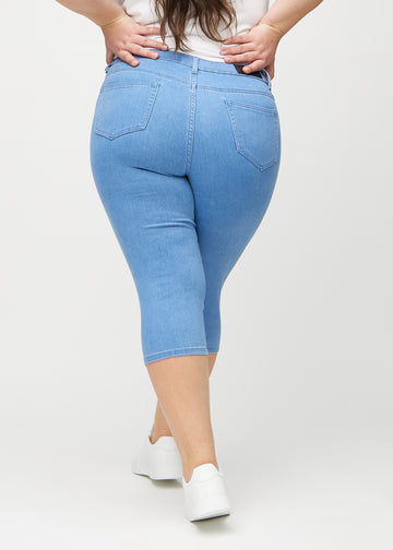 Blue skinny capris seen from the back on a plus-size model, so the full product can be seen.