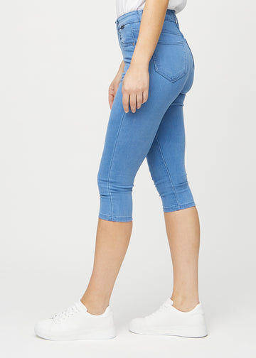 Blue skinny capris seen from the side on a model.