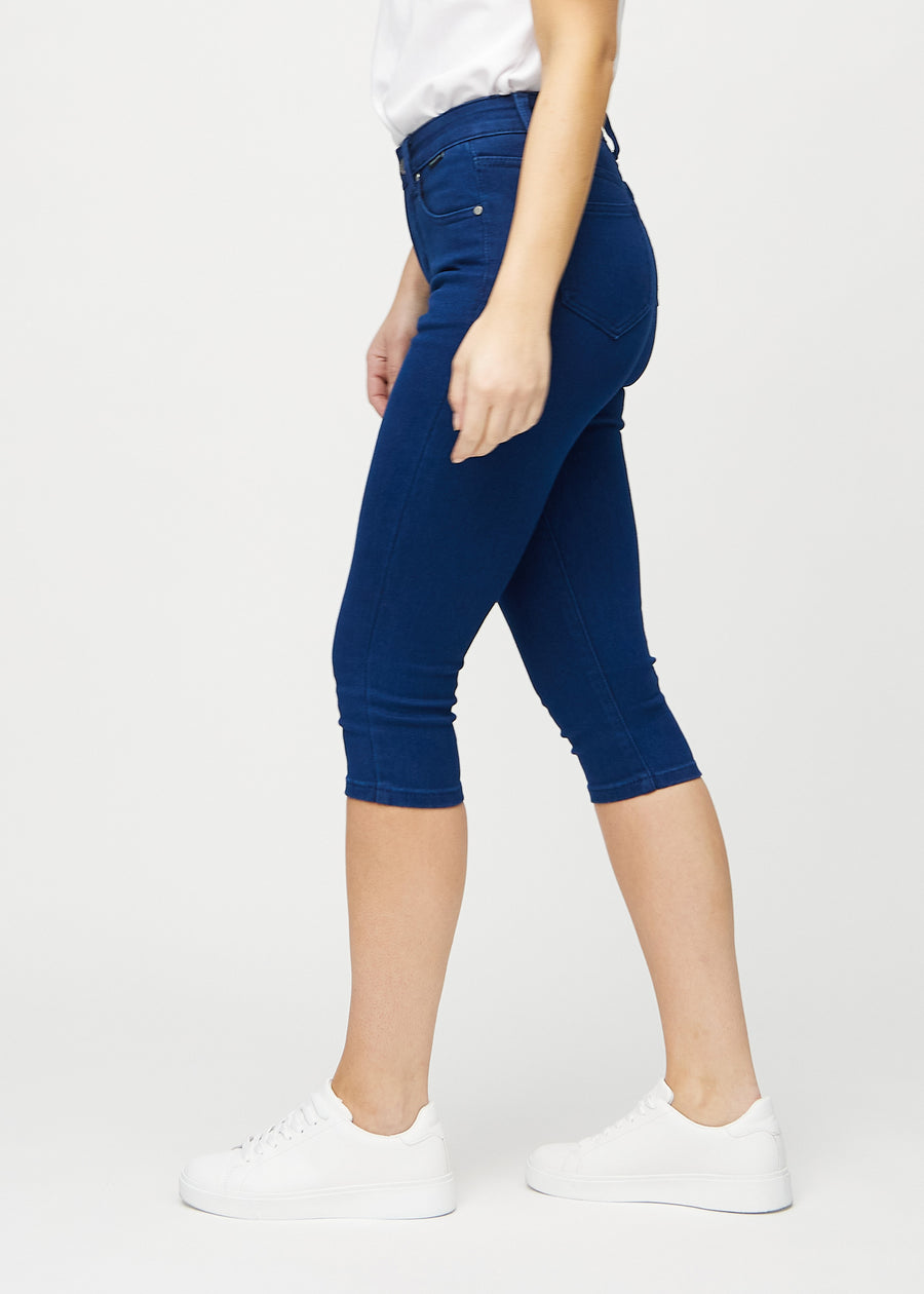 Skinny capris for women in dark blue fabric, color Royals. Side view on a model, showing the fitted cut.