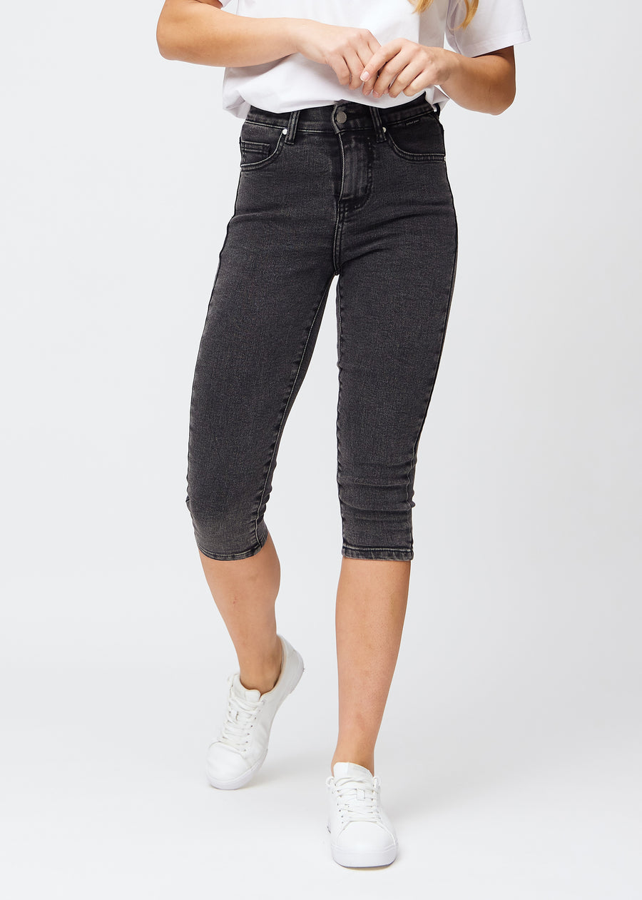 Skinny capris for women in dark grey denim, color Shadows. Front view on a model, showing the close-fitting legs ending just below the knee.