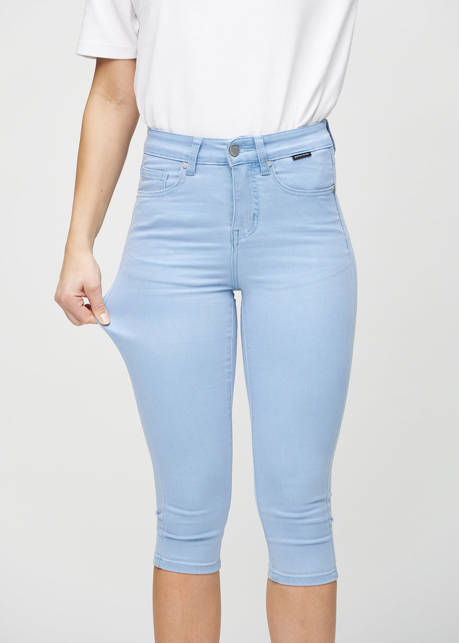The model stretches the capris at the thigh to show the stretch.
