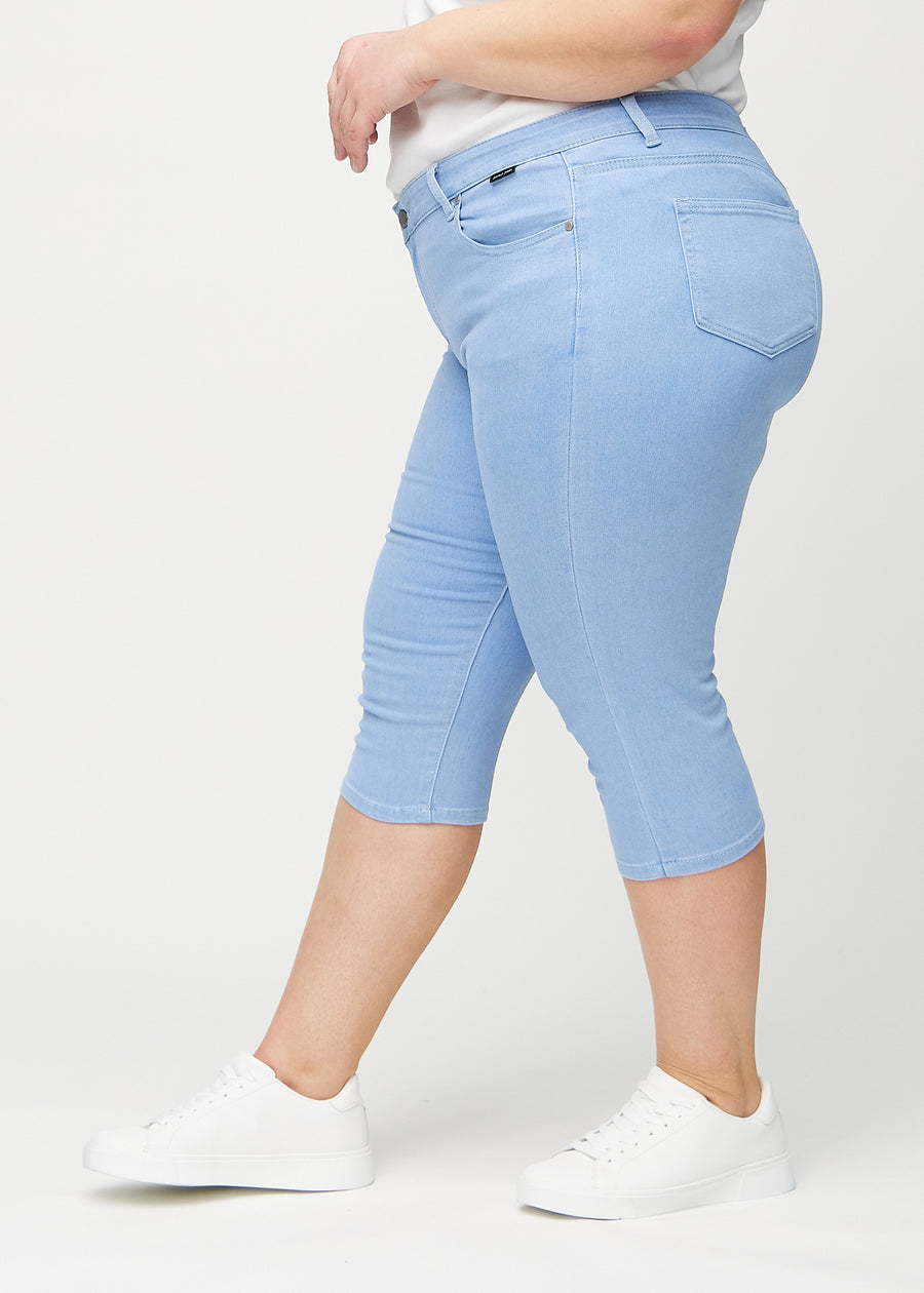 Light blue skinny capris seen from the side on a plus-size model.
