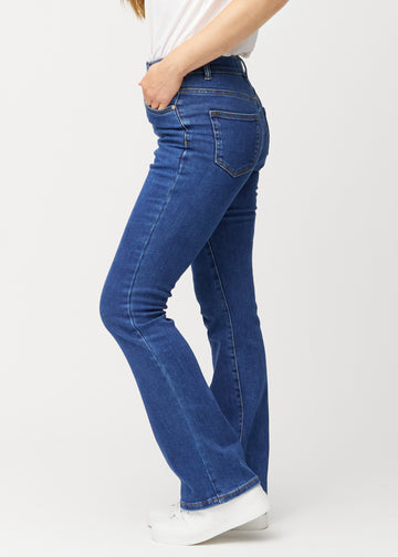 Mørkeblå mid-rise bootcut jeans i denimfarven Oceans set fra siden på model.