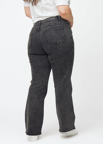 Dark grey mid-rise bootcut jeans in Shadows. Back view on a plus-size model, showing the full fit.