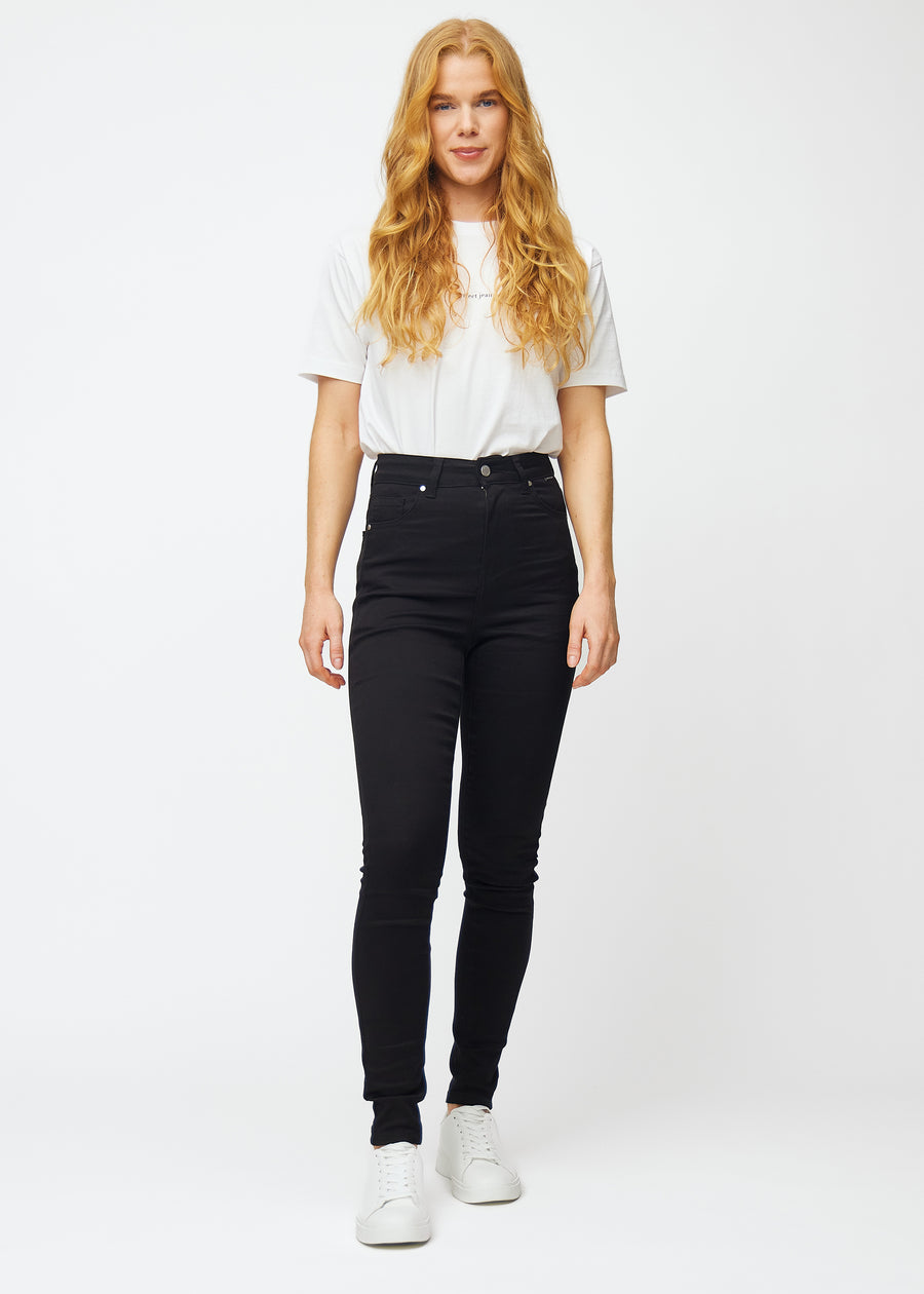 The image shows a full outfit with a model wearing black high rise skinny jeans for women in the color Ravens.