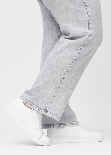 Loose jeans for women in light grey, color Ashes. Close-up at the ankles on a plus-size model, showing the wide leg openings.