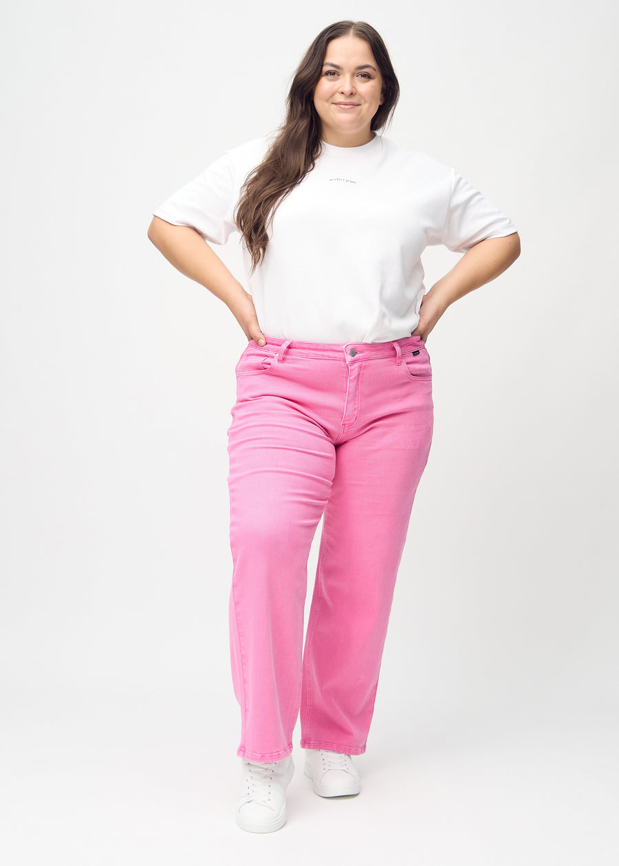 Loose jeans for women in light pink, color Flamingos. Full-length view of a plus-size model wearing the loose-fit jeans.