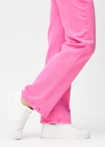 Loose jeans for women in light pink, color Flamingos. Close-up at the ankles on a model, showing the wide leg openings.
