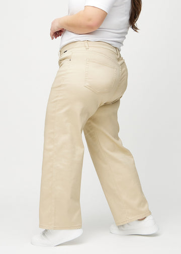 Loose jeans for women in beige, color Gazelles. Side view on a plus-size model, showing the loose fit.
