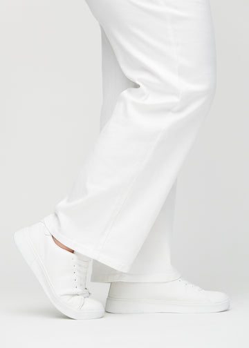 Loose jeans for women in white, color Marguerites. Close-up at the ankles on a plus-size model, showing the wide leg openings.