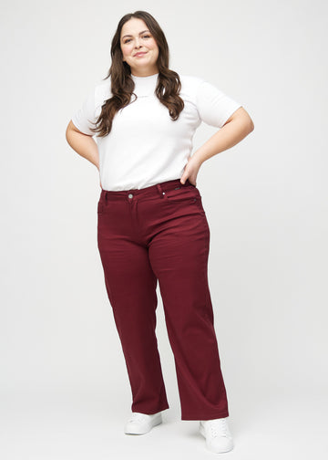 Loose jeans for women in dark red, color Santas. Full-length view of a plus-size model wearing the loose-fit jeans.