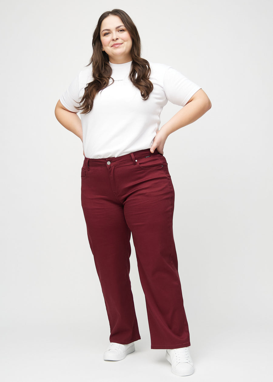 Loose jeans for women in dark red, color Santas. Full-length view of a plus-size model wearing the loose-fit jeans.