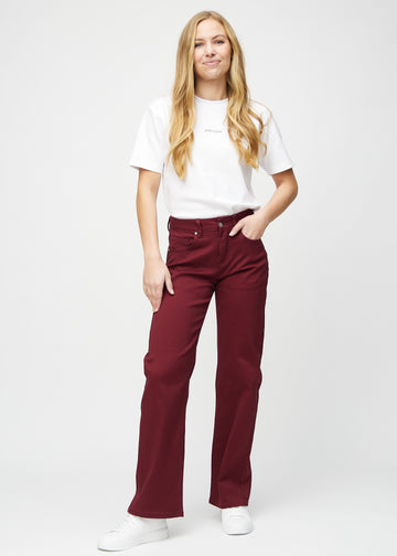 Loose jeans for women in dark red, color Santas. Full-length view of a model wearing the loose-fit jeans.
