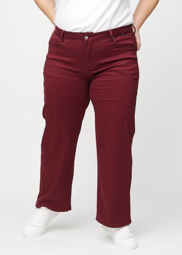 Loose jeans for women in dark red, color Santas. Front view on a plus-size model, showing the roomy, wide-leg fit.