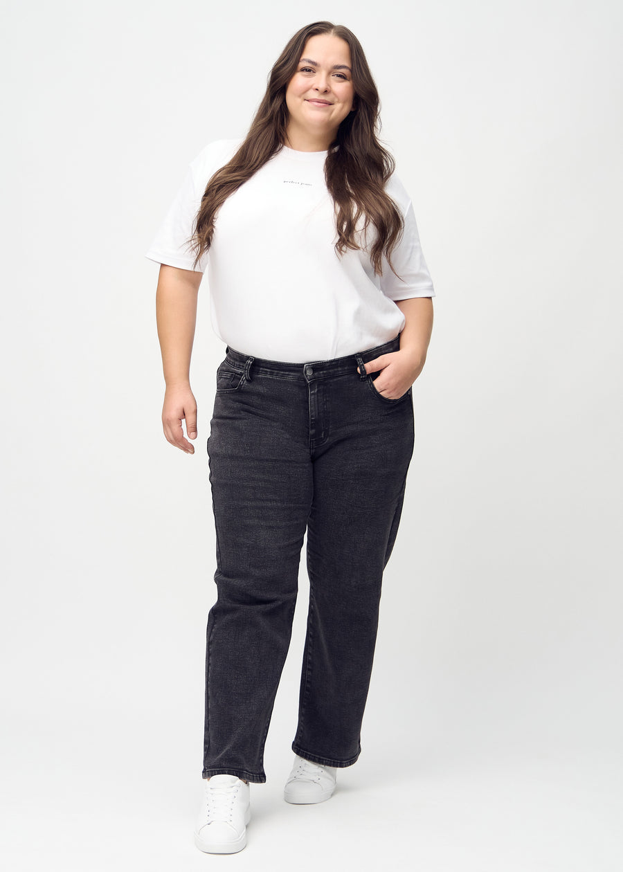 Full image of a plus-size model in dark grey denim loose jeans.