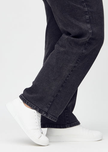 The ankles of a plus-size model, so you can see how loosely the jeans fit.