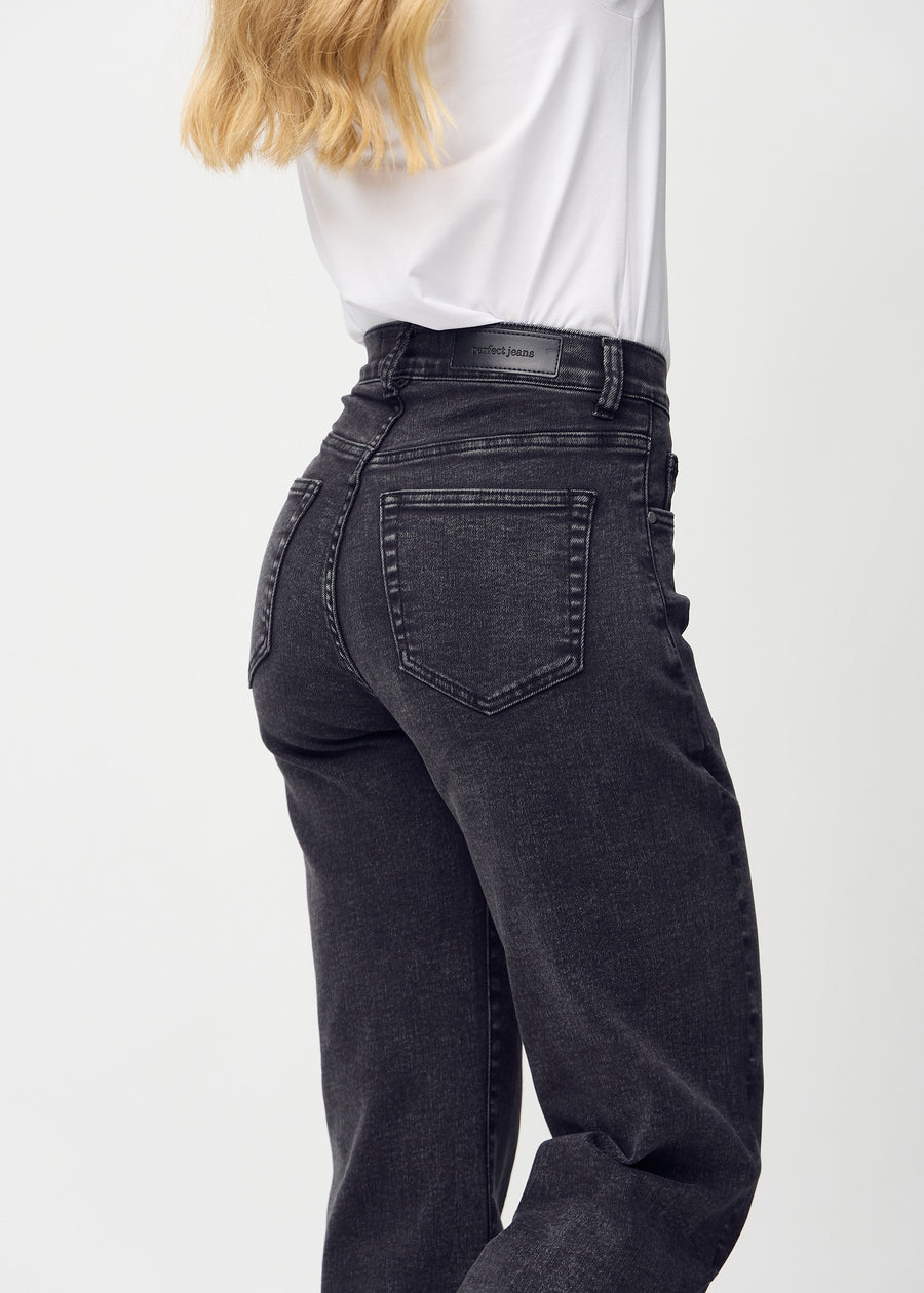 Dark grey denim loose jeans seen from the back close up to show details.