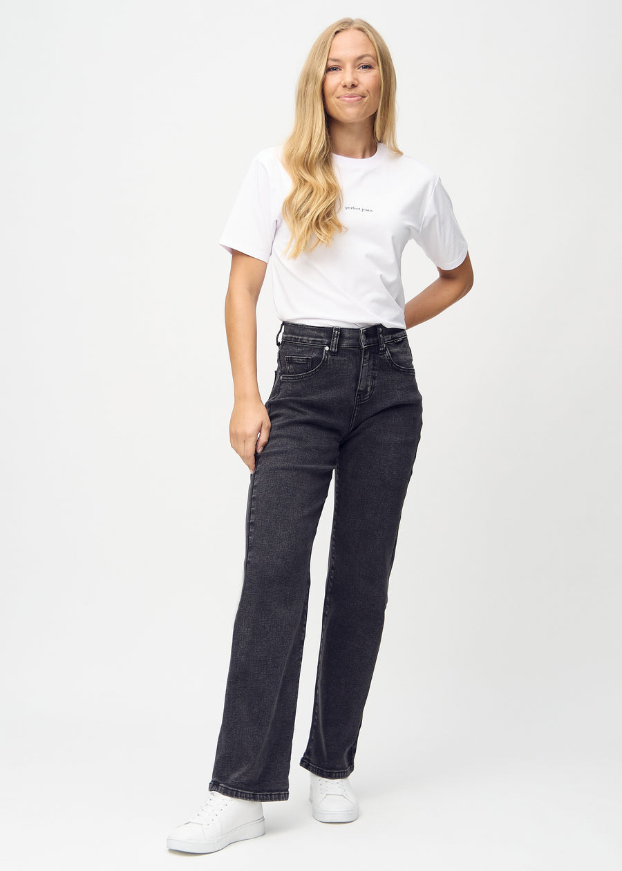 Full image of model in dark grey denim loose jeans.