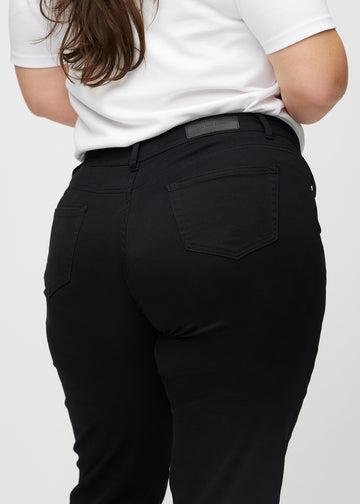 Regular jeans for women in black, color Ravens. Close-up from behind on a plus-size model, showing fit and details.